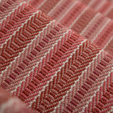 Detail of a stair runner in a complex woven striped runner made of wool in shades of red.