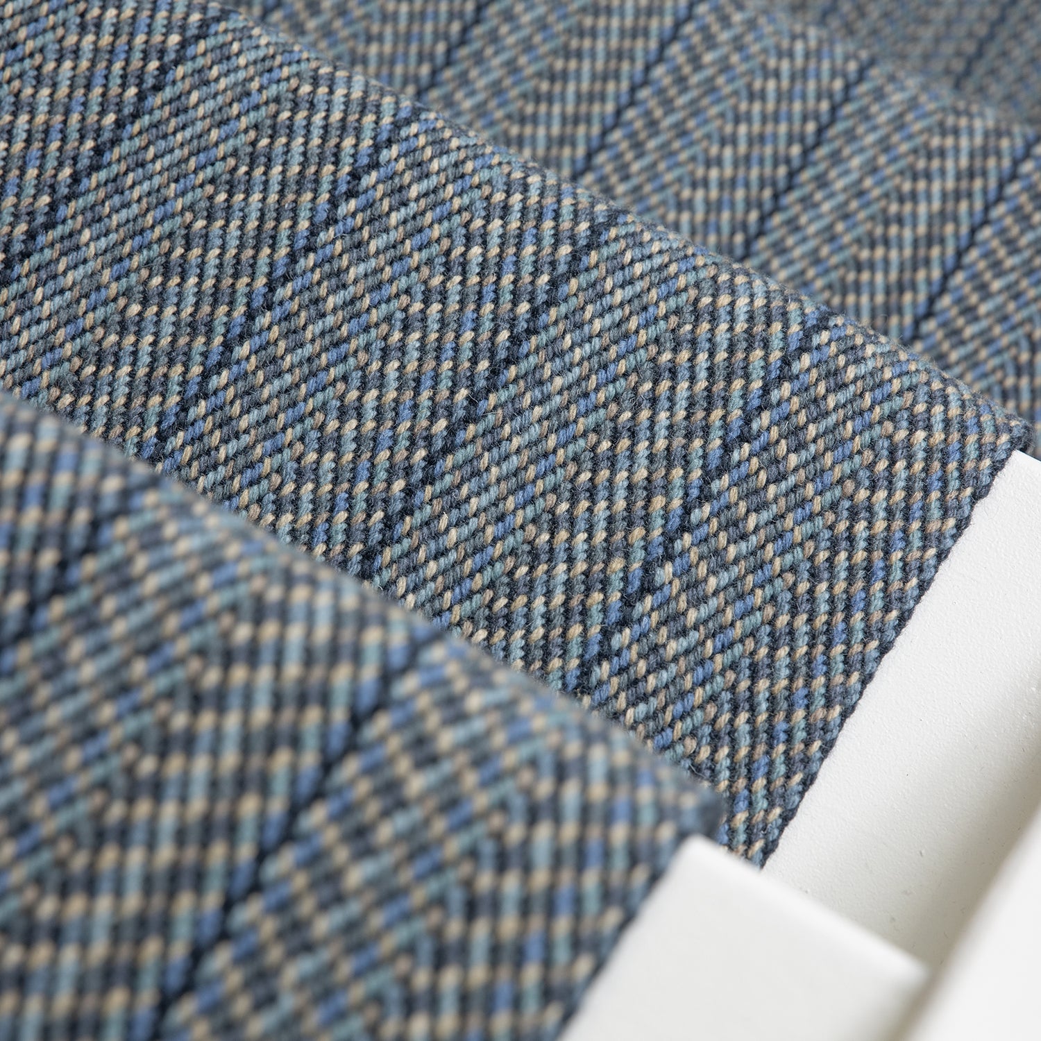 Close-up of a stair runner in blue-gray herringbone weave.