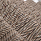 A close-up of a stair runner with a textured stripe in mixed brown, beige, and gray tones.