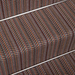 Close-up of a woven stair carpet runner with a textured stripe pattern in pink, brown, beige, and blue.