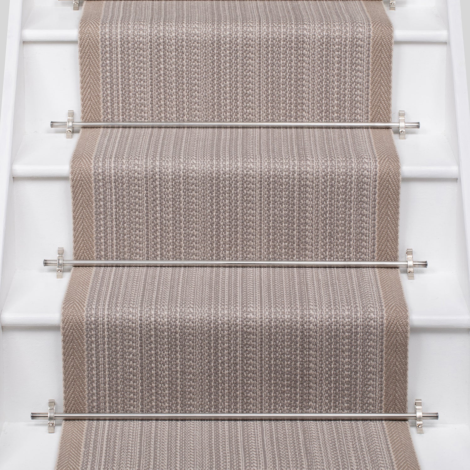 White stairs with textural striped runner in warm beige with metal stair rails. 
