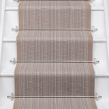White stairs with textural striped runner in warm beige with metal stair rails. 