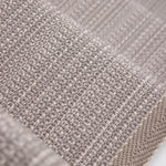 Close-up of flatweave stair runner in a light taupe-beige color, showing the detailed weave and a folded edge.