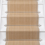 White stairs with textural striped runner in warm tan with metal stair rails. 