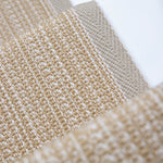 Close-up of flatweave stair runner in warm beige and cream tones, with the stair white surface visible behind them.