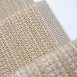 Close-up of flatweave stair runner in warm beige and cream tones, with the stair white surface visible behind them.