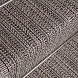 Close-up of a textured stair runner in a heathered gray and black woven pattern, showing the ribbed steps and a metal rail. 