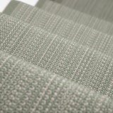 A close-up of a stair runner sample in a muted sage green color textural stripe.