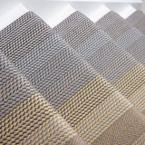 Close-up of carpeted stair treads with a woven herringbone pattern in gray, beige, and brown tones.