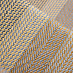 A close-up of a woven stair runner with a herringbone pattern in mustard yellow, light gray, and dark charcoal.