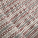 Detail of a stair runner in a complex woven stripe design of wool in shades of pink and grey.