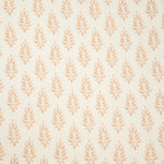 Detail of fabric in a repeating leaf pattern in light pink on a cream field.