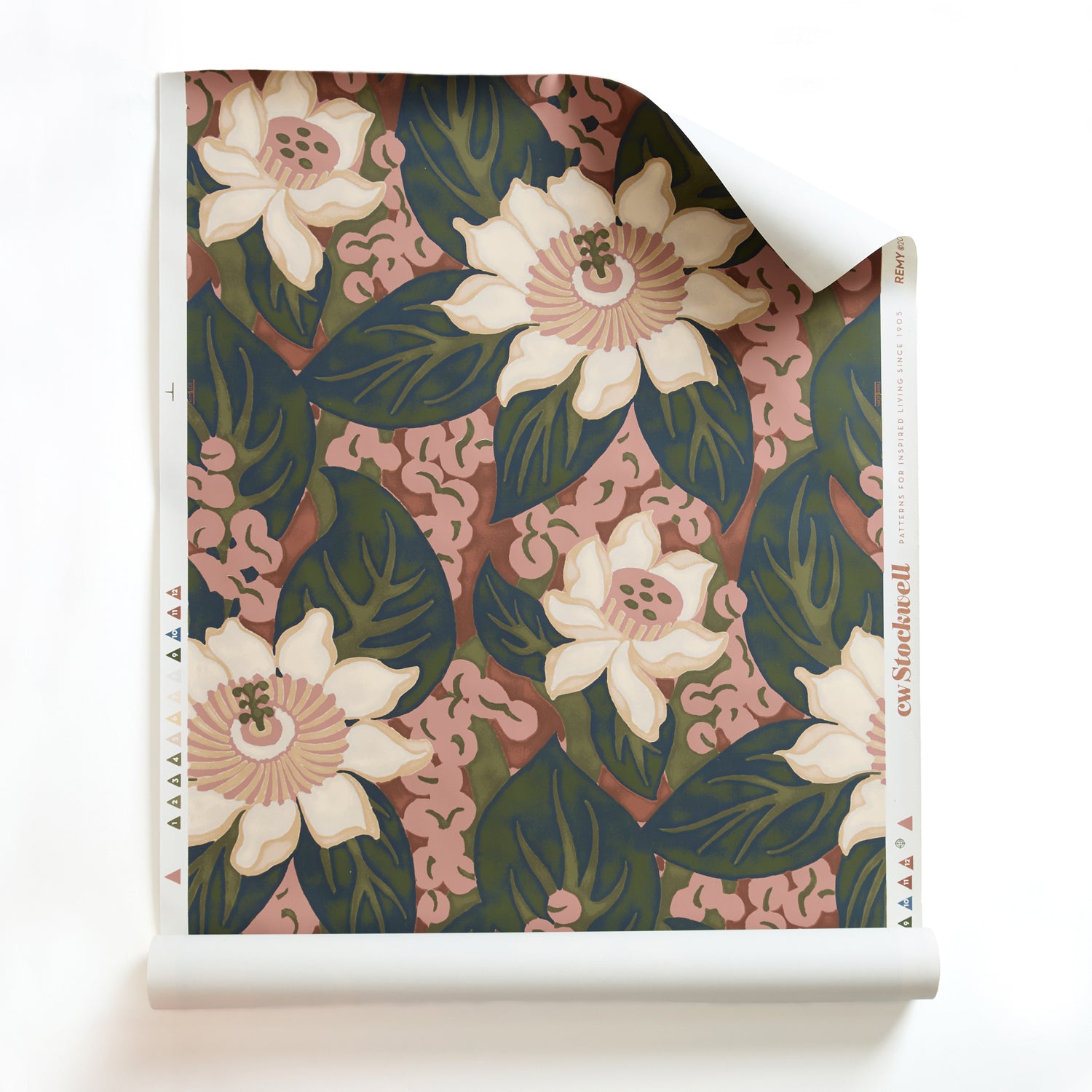 A roll of of tropical floral wallpaper featuring cream-colored blossoms with pink centers, dark green leaves on bright red background. 