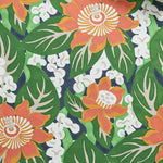 A close-up of a tropical floral wallpaper featuring orange and yellow flowers with white centers, dark green leaves, and small white lily-of-the-valley style blooms on a dark navy background.