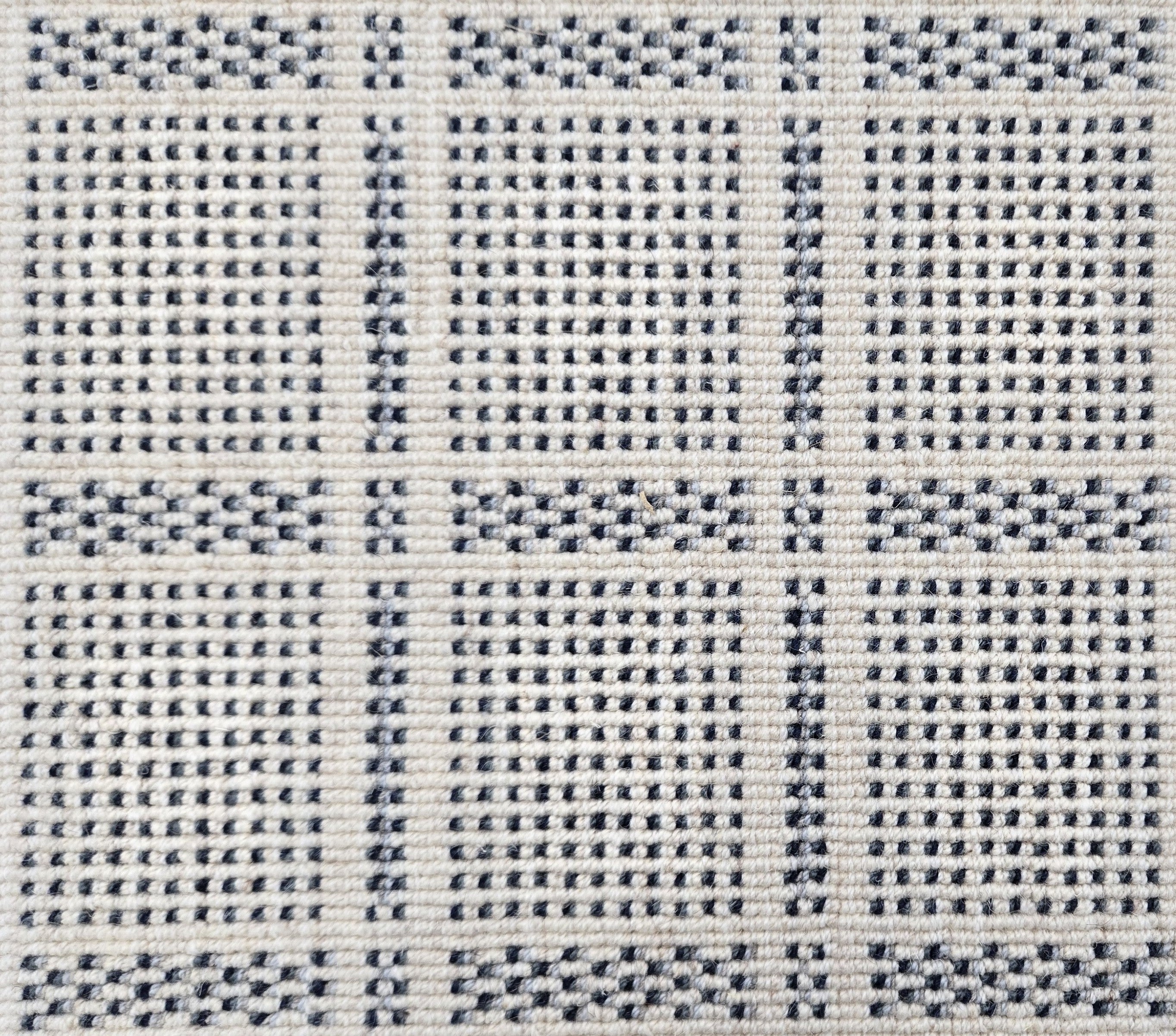 Broadloom carpet in check pattern in shades of dark blue with cream. 