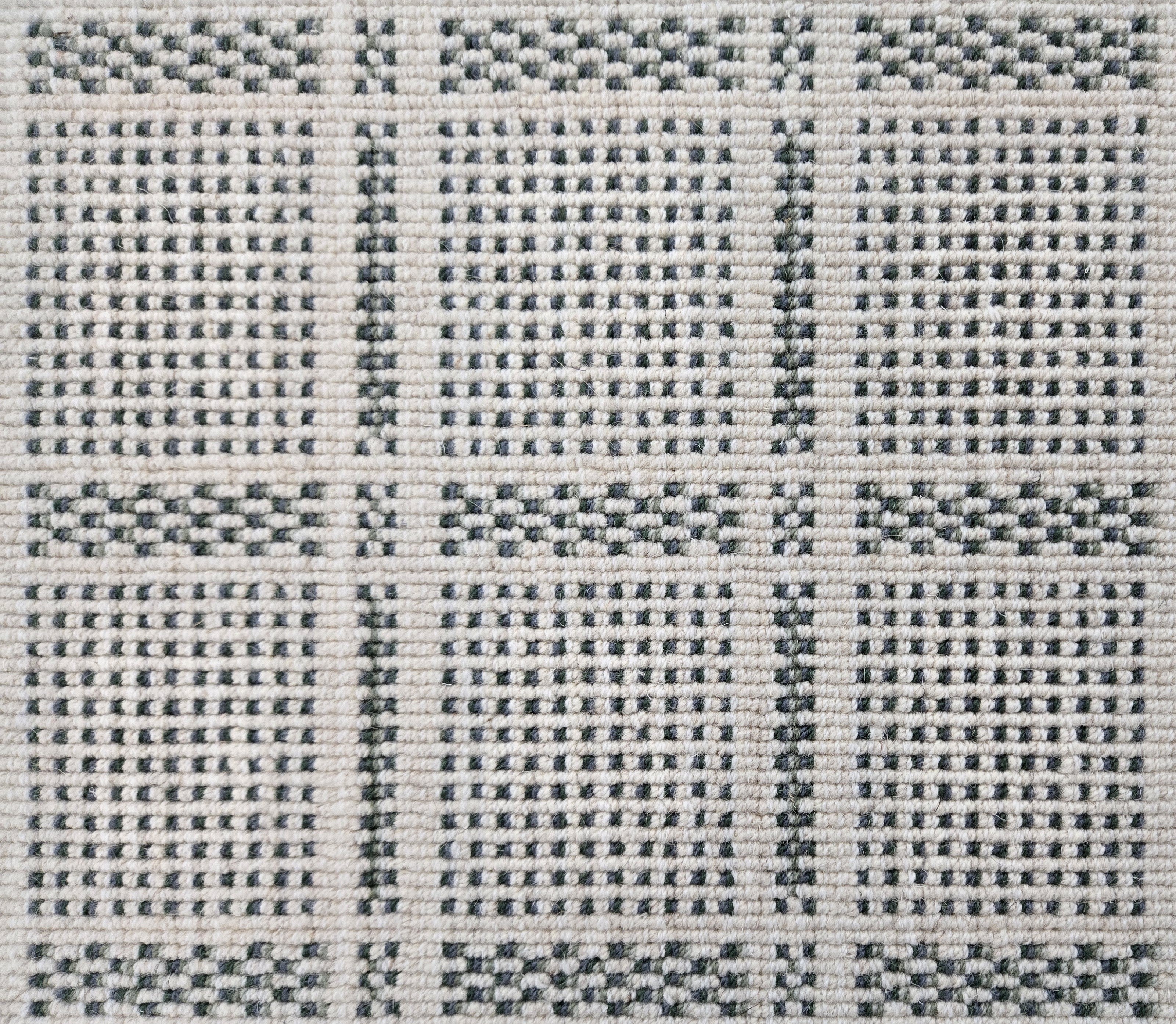 Broadloom carpet in check pattern in shades of dark green with cream. 