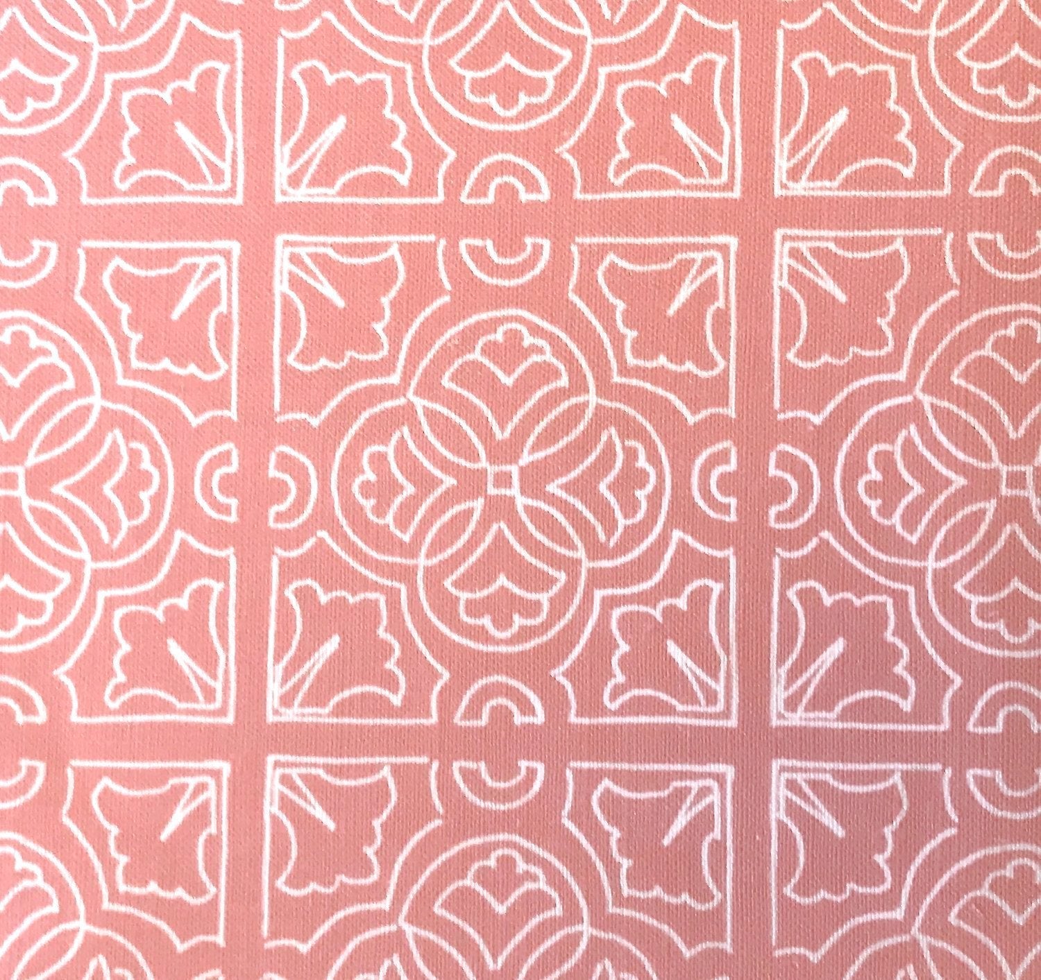 Detail of fabric in a damask lattice print in white on a pink field.