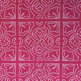 Detail of fabric in a damask lattice print in pink on a fuchsia field.