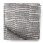 A stack of fabric swatches in a small-scale checked pattern in shades of blue-gray.