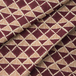 Draped fabric with a geometric pattern of triangles in wine purple and brown.