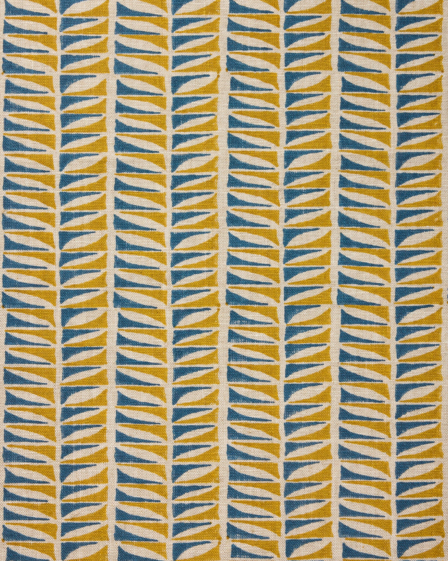 Close-up of fabric with a geometric leaf pattern in blue and ochre.