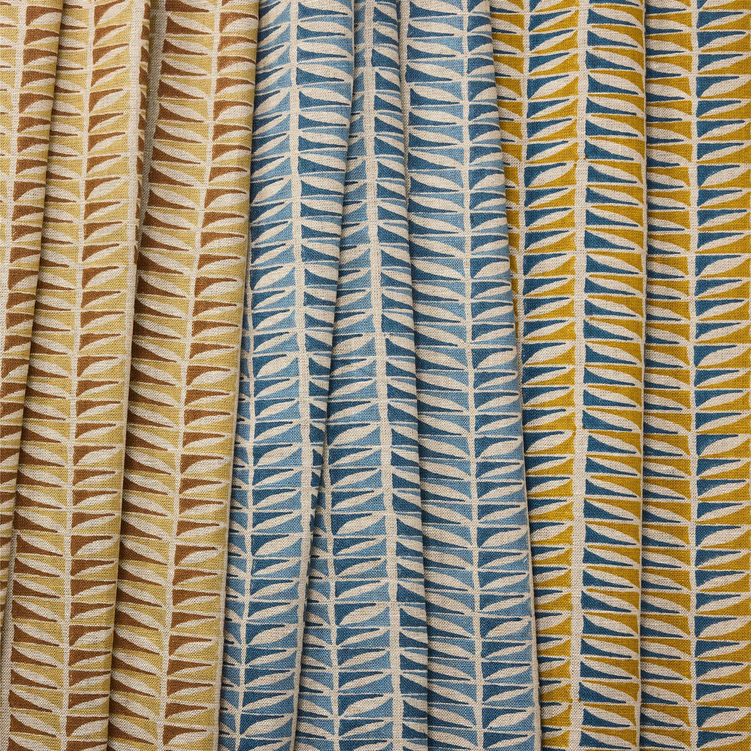 Three fabric swatches with geometric leaf pattern in blue, beige, and multicolor.