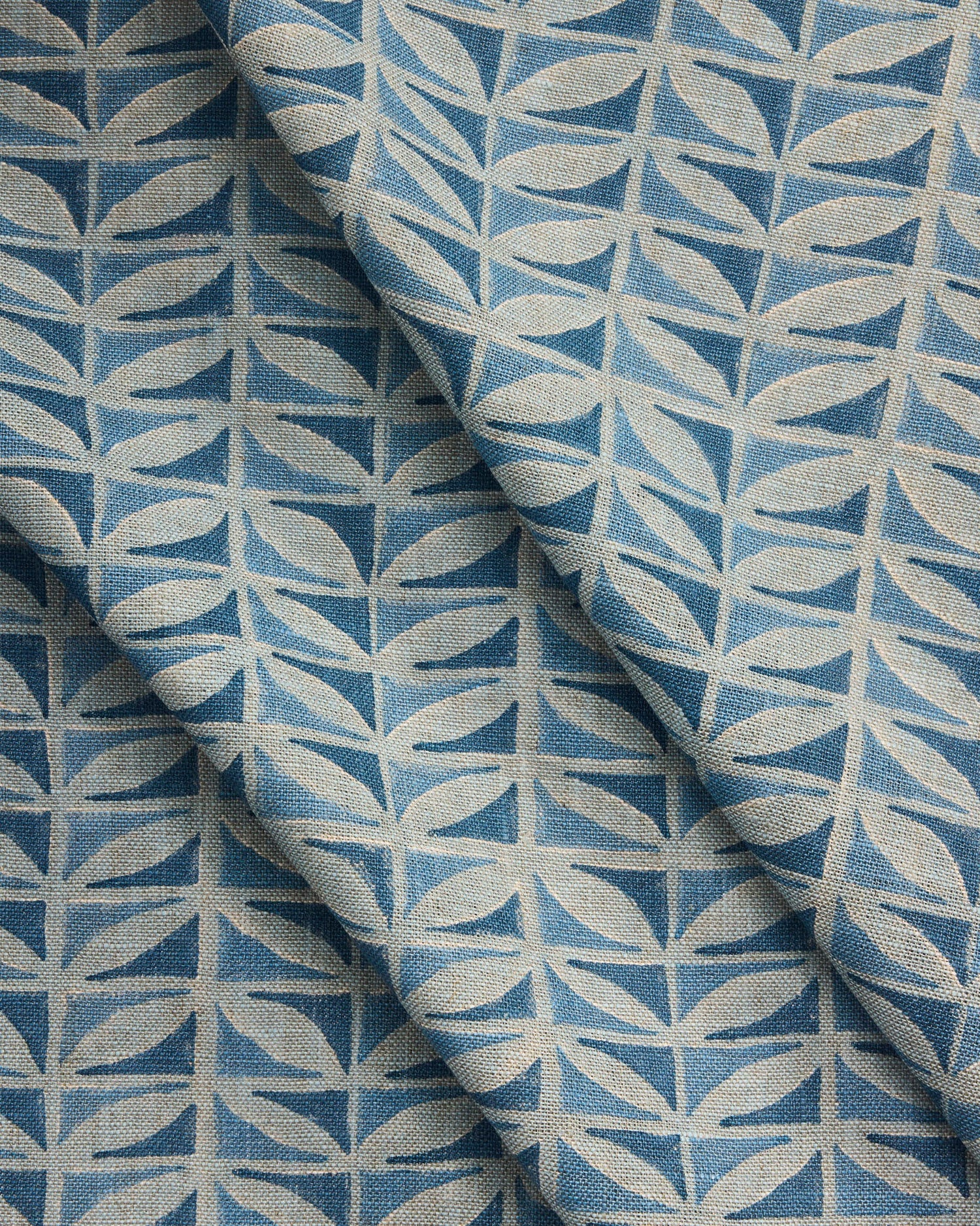 Draped close-up of fabric with a leaf pattern in shades of blue.