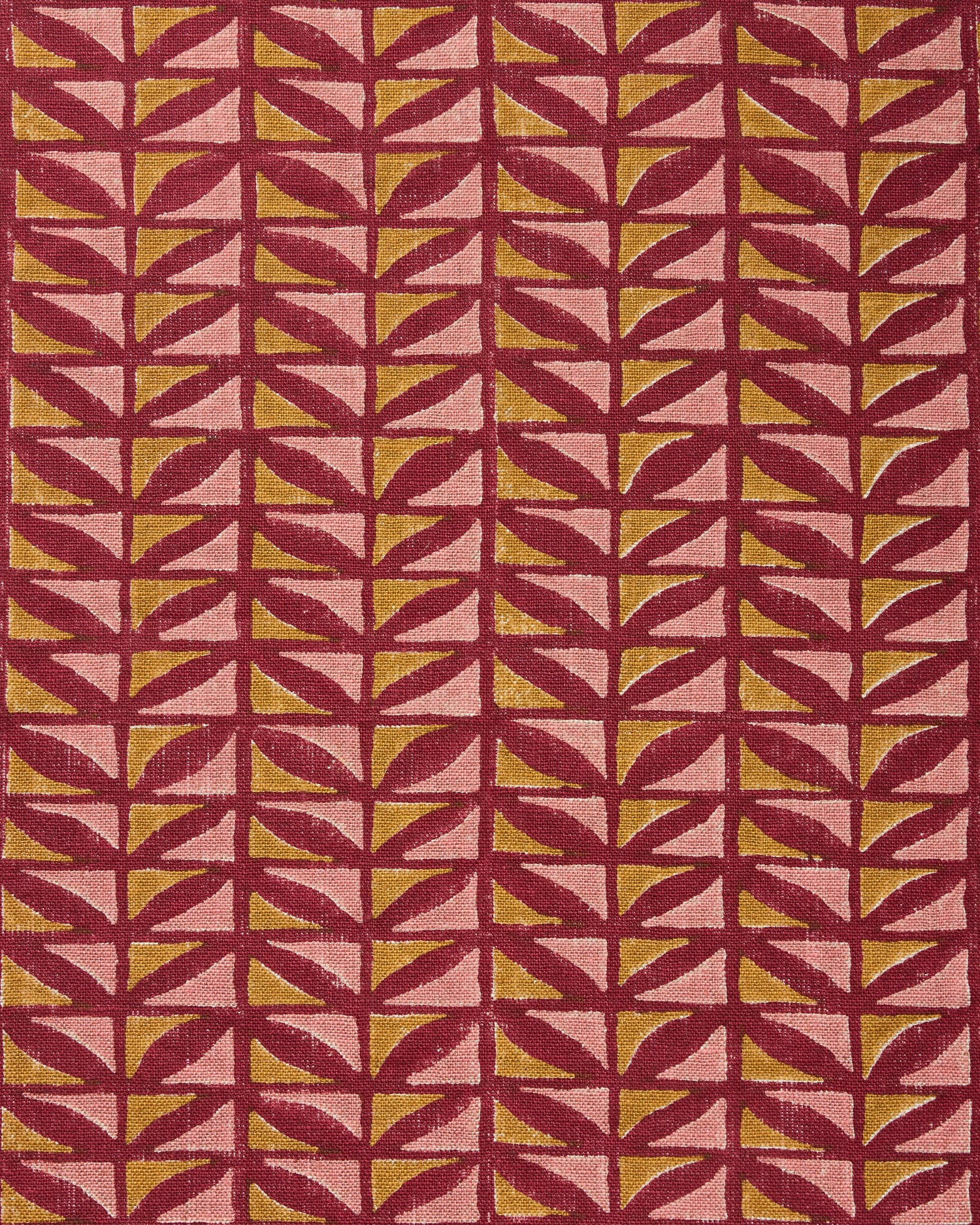 Close-up of fabric with geometric pattern in pink and ochre on a crimson field. 