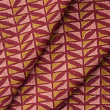 Draped close-up of fabric with geometric pattern in pink and ochre on a crimson field. 