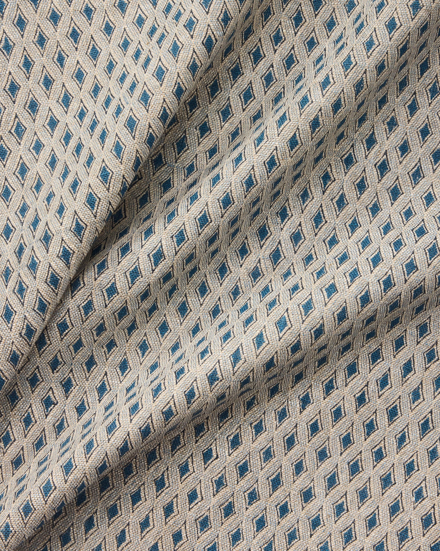 Draped close-up of patterned fabric with blue diamond shapes