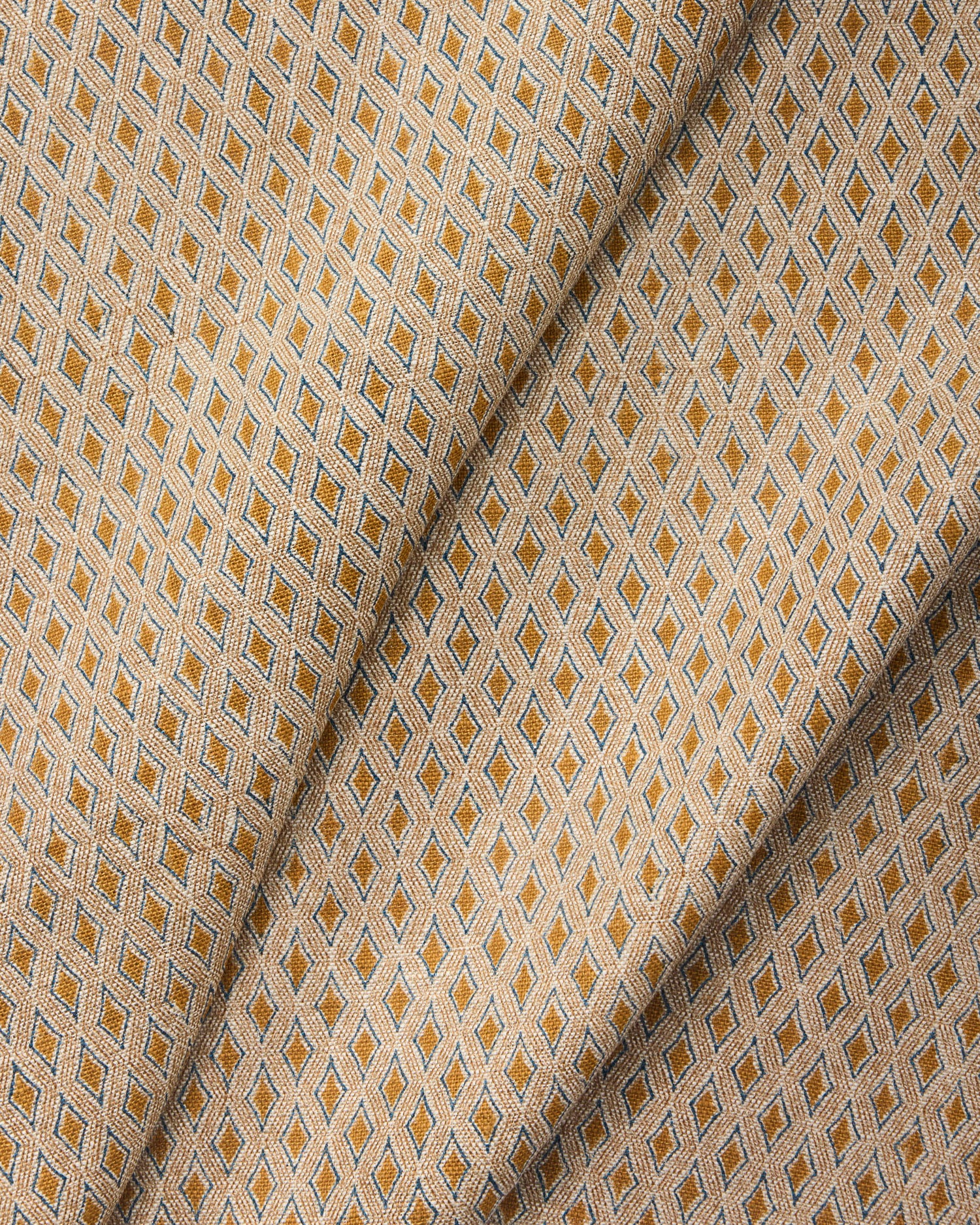 Draped fabric with a geometric pattern in beige and brown tones.