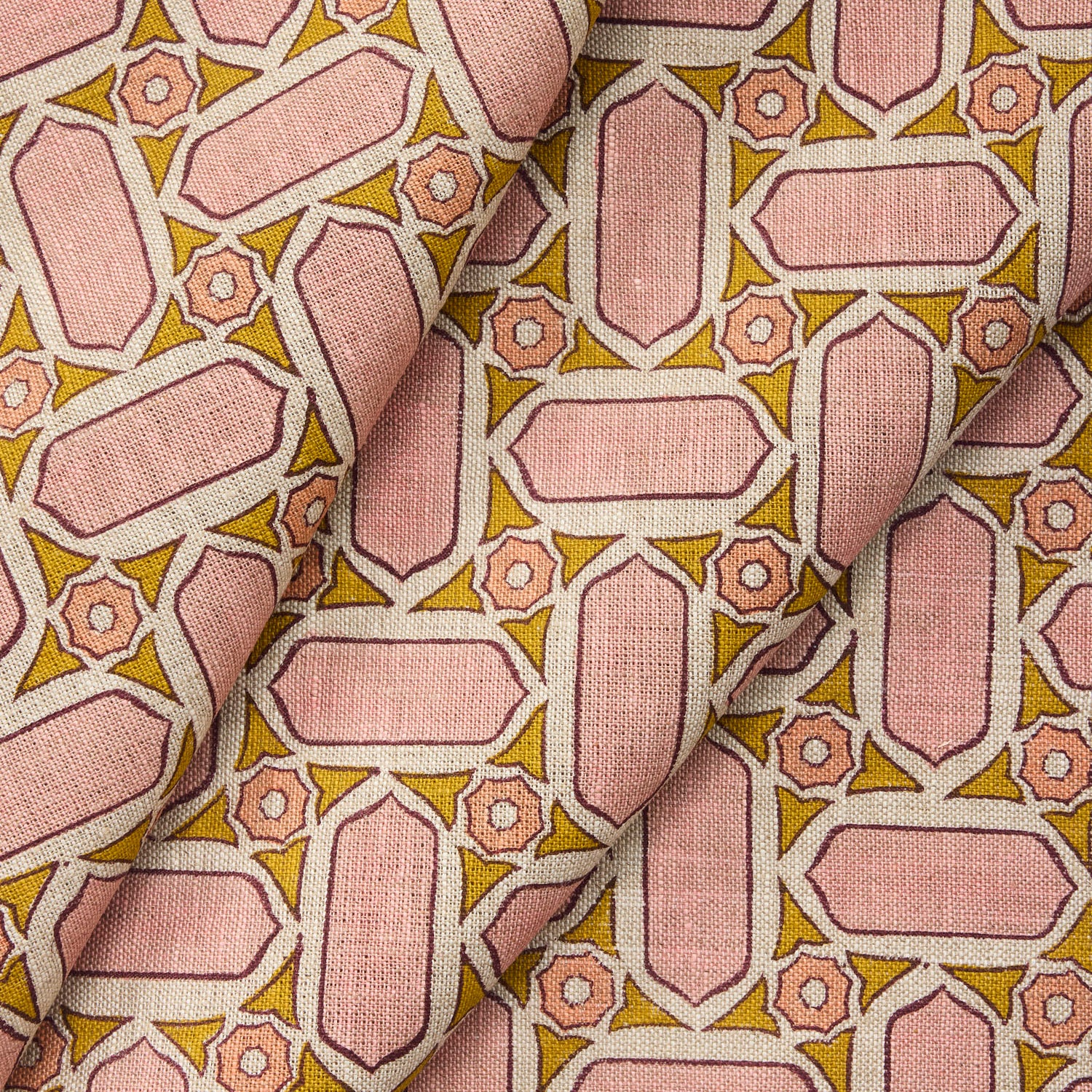 Draped fabric with geometric mosaic pattern of pink and green.