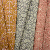 Three fabric swatches with geometric sun patterns in yellow, blue, and pink.
