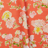 Folded linen swatch with a pattern of large-scale line-drawn flowers in gray ink with red, pink and yellow watercolors, on a red background.