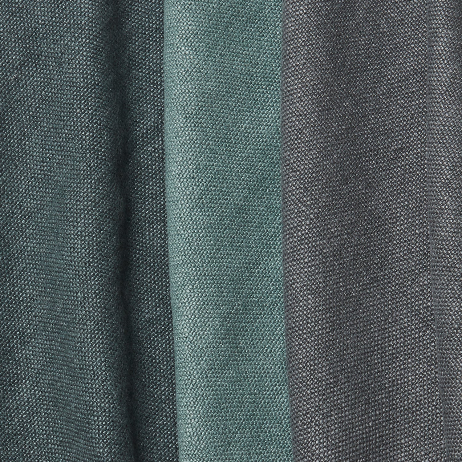 A group of folded linen swatches in various shades of dark green and gray.