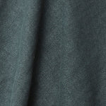 A draped swatch of old-world linen fabric in a solid dark green-gray color.