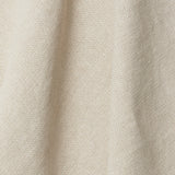 A draped swatch of old-world linen fabric in a solid cream color.