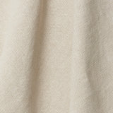 A draped swatch of old-world linen fabric in a solid cream color.