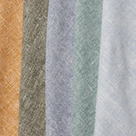 A row of folded linen swatches in mottled shades of blue, green, gray, brown and mustard.