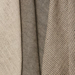 Group of three folded linen swatches in three different small-scale patterns, all in shades of tan and black.