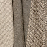 Group of three folded linen swatches in three different small-scale patterns, all in shades of tan and black.