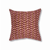 Block printed lumbar pillow with gridded leaf design in wine red with tan and pink accents. 