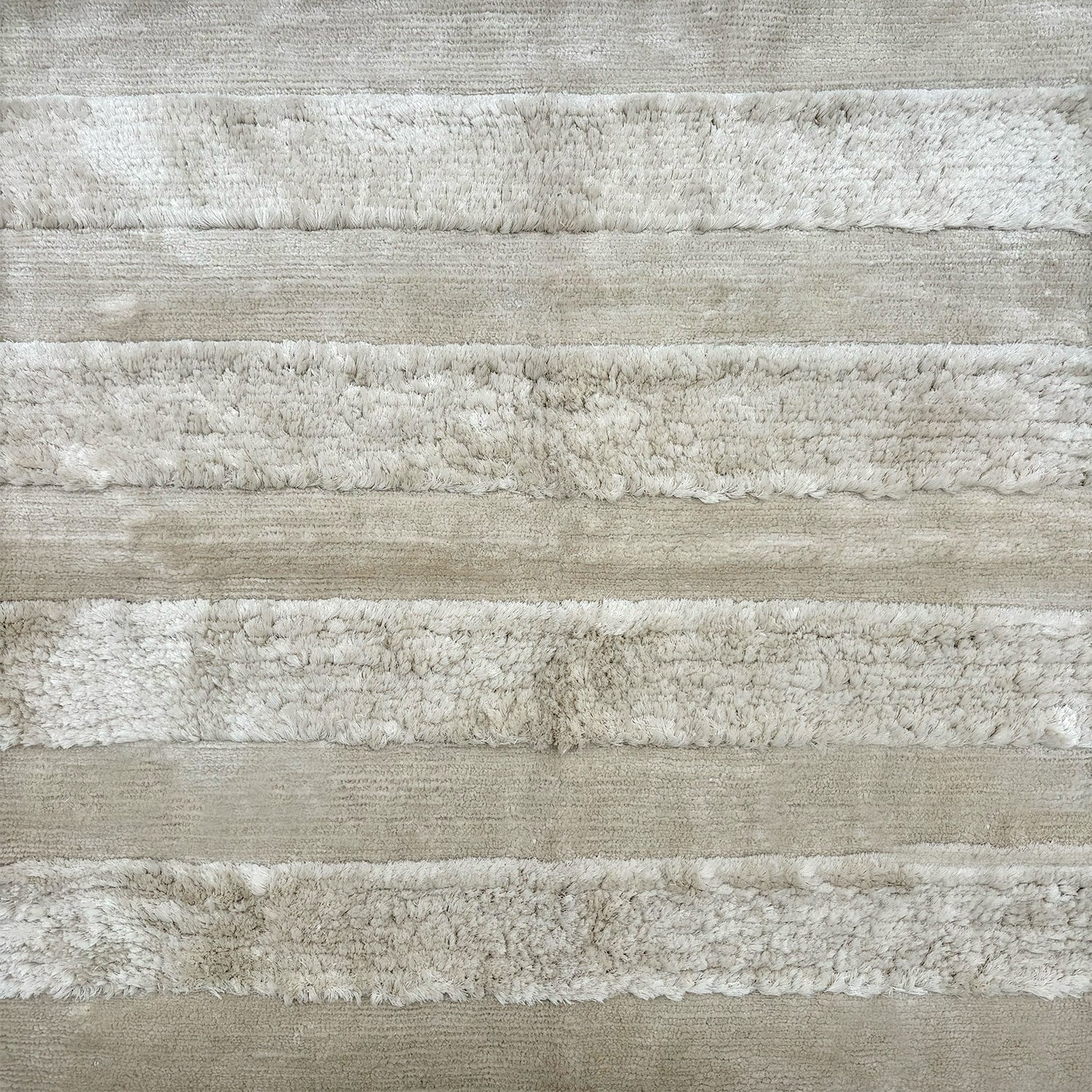 Detail of a wool rug with wide stripes in alternating heights. 