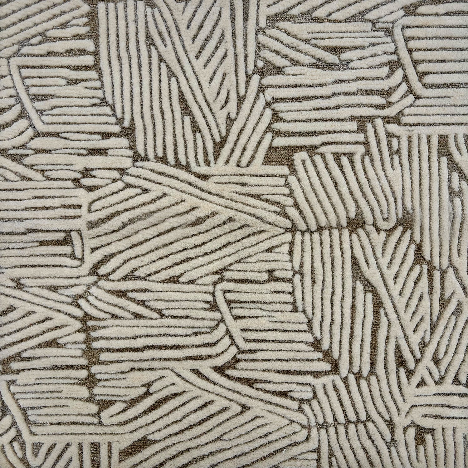 Detail of rug with an abstract woodcut inpsired pattern in grey and cream