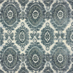 Detail of a handknotted rug with a floral medallion pattern in shades of acqua and grey. 