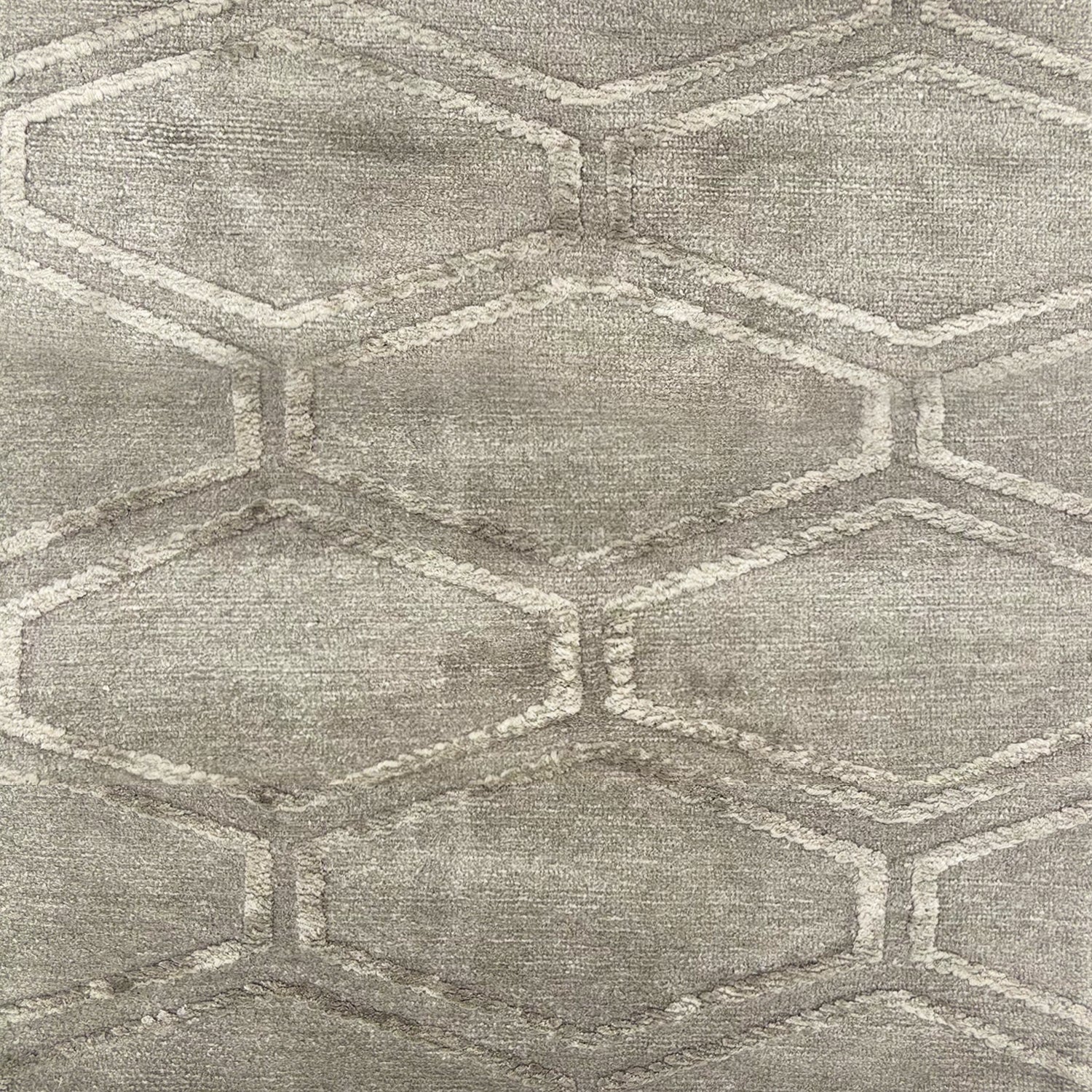 Detail of handknotted rug in grey featuring a hexagon lattice pattern