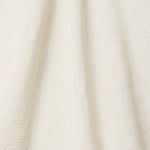 A draped swatch of open-weave sheer interior fabric in a cream color.