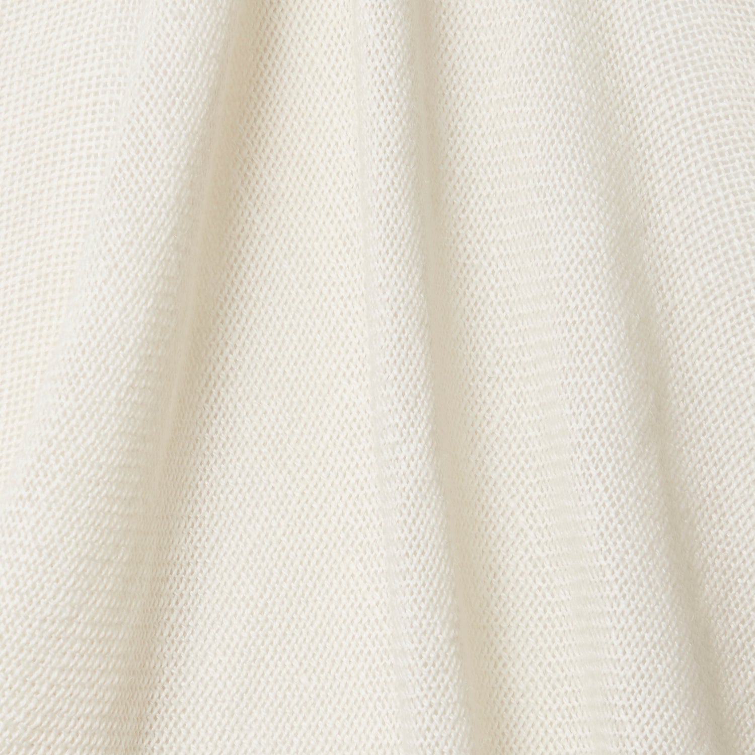 A draped swatch of open-weave sheer interior fabric in a cream color.