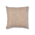 A square throw pillow featuring a dense, small-scale geometric diamond pattern in muted terracotta red and blue on a plain white studio background.
