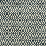 Detail of a handowven rug in an diamond like pattern in white and shades of blue.